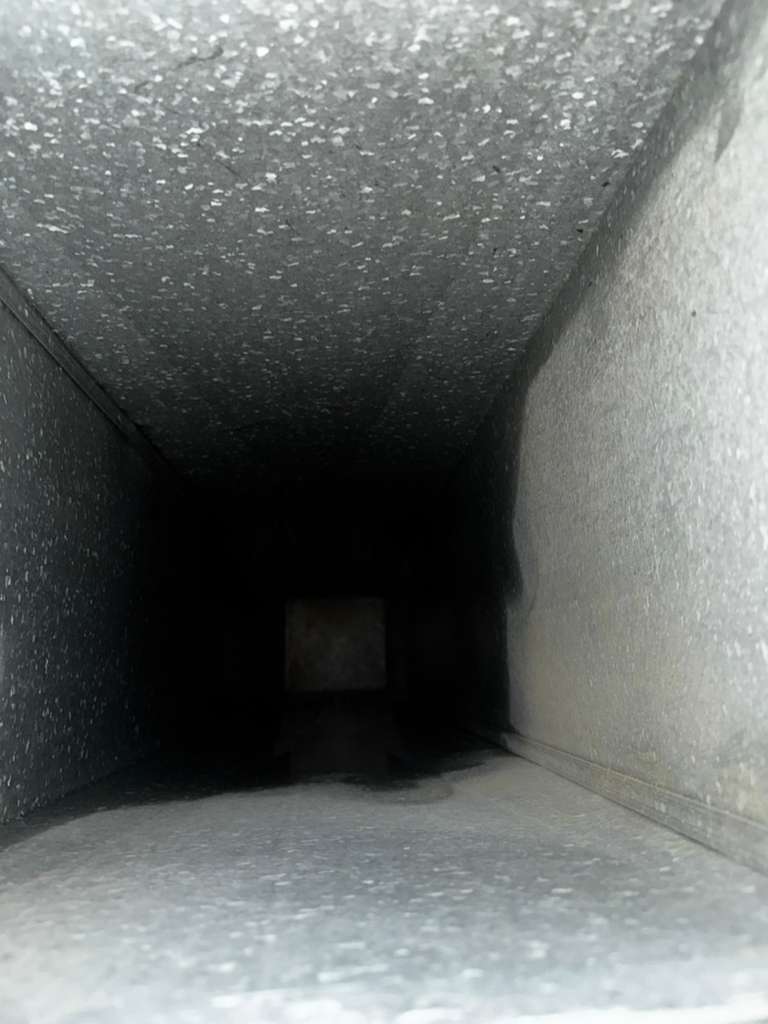 Inside a freshly cleaned supply trunk after Eagle Air Duct Cleaning — galvanized steel walls clean of dust and biofilm
